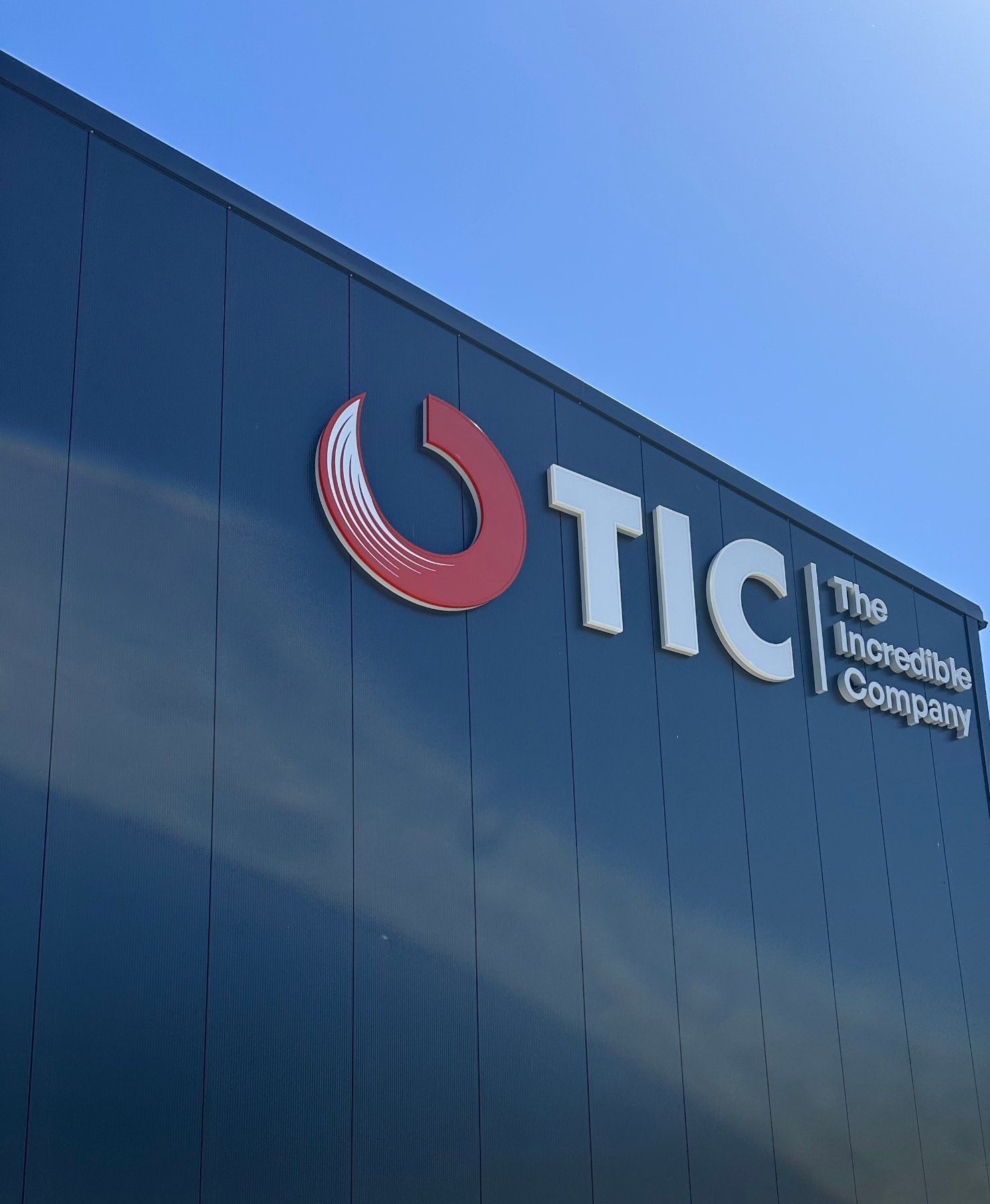 Close-up of the TIC logo on the facade of our logistics centre in Bredenbek
